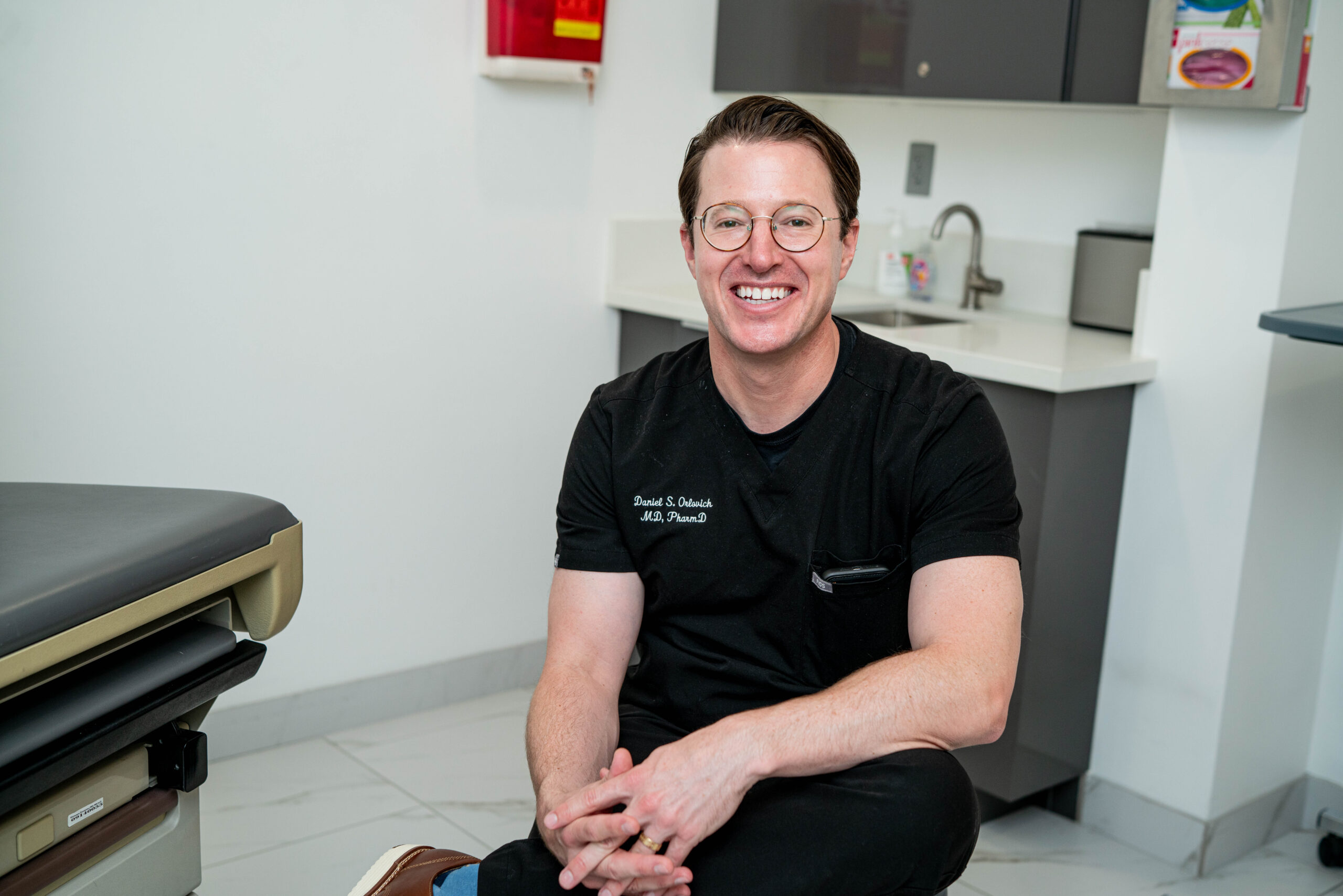Dr. Daniel Orlovich pain management physician smiling in exam room in Los Angeles clinic