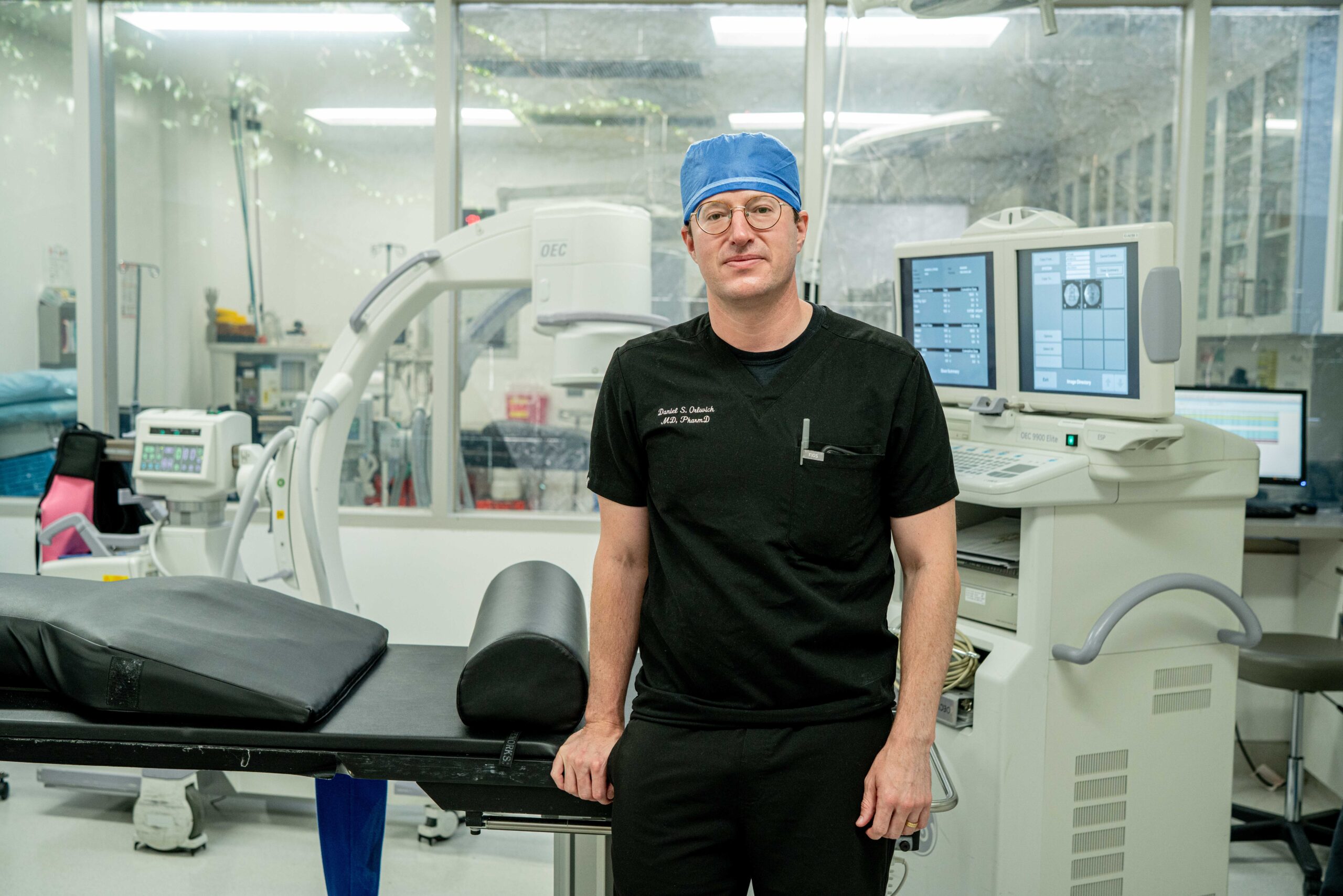 Dr. Daniel Orlovich, MD, PharmD, QME in procedure room with fluoroscopy equipment in Los Angeles and Sacramento